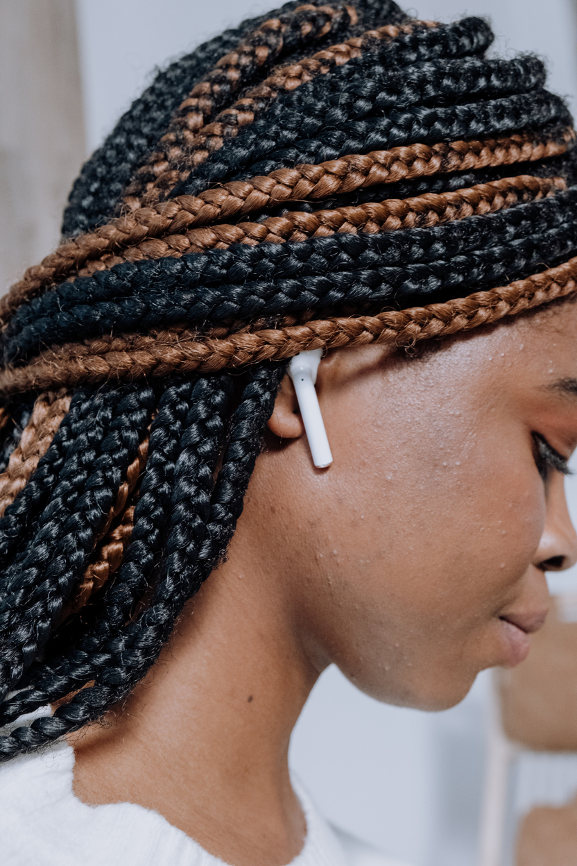 Woman With Braided Hair Wearing White Earbuds